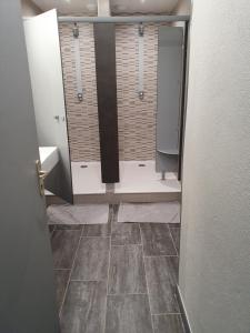 a bathroom with a shower and a tiled floor at La Marmotte De La Meije in Le Bourg-dʼOisans