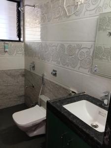 a bathroom with a sink and a toilet and a mirror at Estudio 007, Palolem in Canacona +7 photos