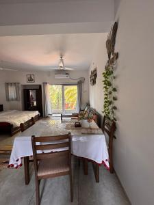 a dining room with a table and chairs and a bed at Estudio 007, Palolem in Canacona