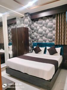 a bedroom with a large bed in a room at Hotel Sunlight in Ahmedabad