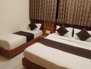 a bedroom with two beds and a window at Hotel Sunlight in Ahmedabad