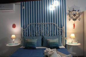a bedroom with a bed with blue and white stripes at Oasi Del Gabbiano in Syracuse