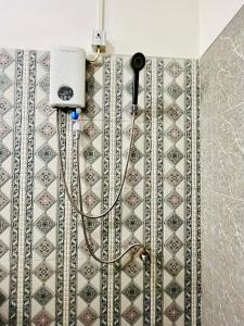 a shower with a hose attached to a wall at Comfort Home stay Private Room A Shared House in Ban Tha Khun