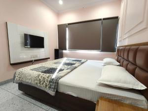a bedroom with a large bed and a flat screen tv at Hotel Kanak Shree in Godarpura