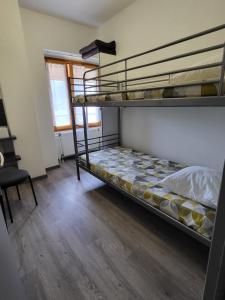 a bedroom with two bunk beds and a chair at La Marmotte De La Meije in Le Bourg-dʼOisans