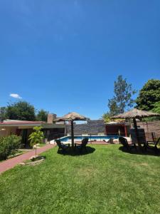 a park with chairs and tables and umbrellas at Complejo de departamentos 7 Cielos in Villa Carlos Paz