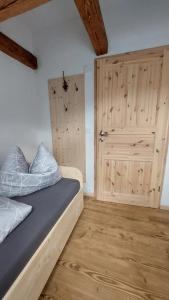 ein Schlafzimmer mit einem Bett und einer Holztür in der Unterkunft Oderlandblick Apartment in Friedersdorf
