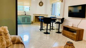 a living room with a table and chairs and a kitchen at Apartment Voula Myrtos in Anomeriá