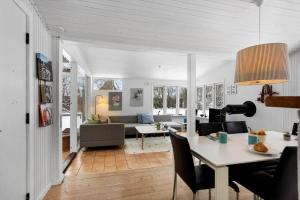 a dining room and living room with a table and chairs at LL267-Tranekaer-Bellisvej-2 in Stoense