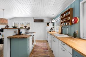 a kitchen with white cabinets and blue walls at LL267-Tranekaer-Bellisvej-2 in Stoense +13 photos