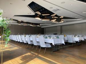 a banquet hall with white tables and white chairs at Hotel Cztery Korony in Śrem