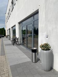 a building with large glass doors on a sidewalk at Hotel Cztery Korony in Śrem