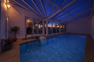 a swimming pool in a house with a ceiling at L'écrin fleuri in Allerey