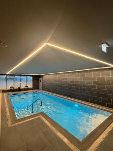 a large swimming pool with blue water in a building at DOMITYS - L'Elyme des sables in Neufchâtel-Hardelot
