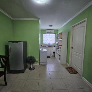 a kitchen with green walls and a refrigerator in a room at One oasis condo 1bedroom Ltype in Davao City