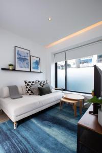a living room with a white couch and a tv at Ariama Serviced Residence in Jakarta
