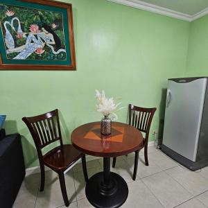 a table with two chairs and a refrigerator in a room at One oasis condo 1bedroom Ltype in Davao City