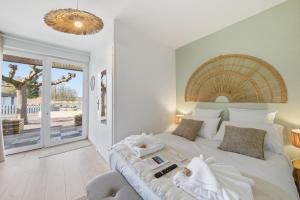 a bedroom with a large white bed with a large window at L'écrin fleuri in Allerey +41 photos