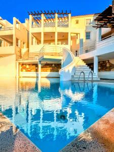 a swimming pool in front of a building at Lime Andros Maisonette by HOSTANDROS in Apróvaton