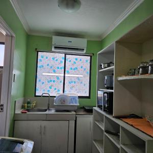 a kitchen with a large window and a sink at One oasis condo 1bedroom Ltype in Davao City +4 photos