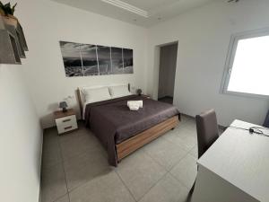 a bedroom with a bed in a white room at Lux Maris in Mazara del Vallo