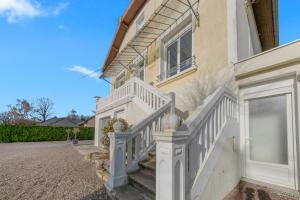 a house with white stairs on the side of it at L'écrin fleuri in Allerey