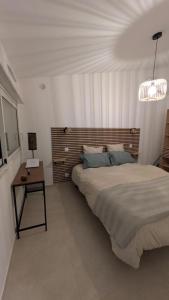 a bedroom with a bed and a table and a lamp at Chez Lucia petite maison a la campagne pour 4 pers ,parking prive in Istres
