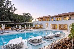 a swimming pool with lounge chairs and a resort at Grand Elis Hotel & Spa Resort in Kourouta