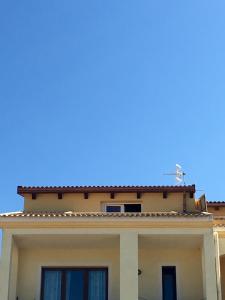un edificio con un cielo azul en el fondo en La Spiga Apartments, en Castelsardo