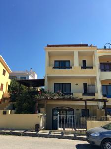 un edificio con un'auto parcheggiata di fronte di La Spiga Apartments a Castelsardo