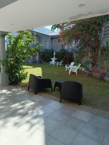 a patio with chairs and tables and a lawn at Clima Termal Suites in Federación