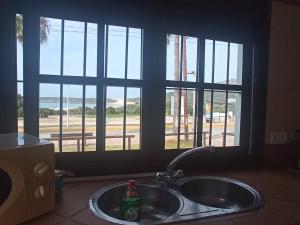 a sink in a kitchen with a view of a street at BOL16 in Bolonia +38 photos