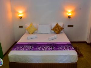 a bedroom with a large bed with purple sheets at Mount Lily Mirissa in Mirissa +8 photos