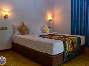 a large bed in a room with blue drapes at Mount Lily Mirissa in Mirissa