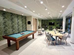 a pool table in a room with tables and chairs at DOMITYS - L'Elyme des sables in Neufchâtel-Hardelot