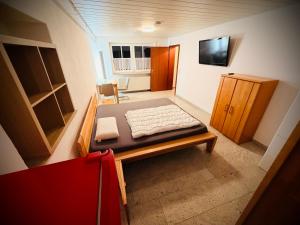 a small room with a bed and a cabinet at Familie-Ising aus de in Unterwörnitz