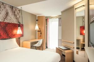 une chambre d'hôtel avec un lit et une fenêtre dans l'établissement Ibis Paris Gare Montparnasse 15ème, à Paris