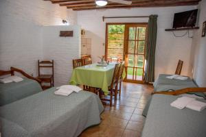 a room with two beds and a table with a green table cloth at Apart Hotel Manantiales Termal in Termas del Daymán