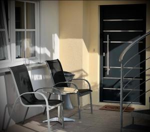 two chairs and a table in front of a door at Familie-Ising aus de in Unterwörnitz