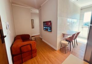 a living room with a chair and a table at Apartamento com ar condicionado e lava e seca in Cascavel