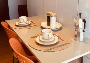 a table with three cups and saucers on it at Apartamento com ar condicionado e lava e seca in Cascavel +29 photos