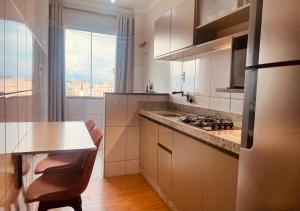a kitchen with white cabinets and a counter top at Apartamento com ar condicionado e lava e seca in Cascavel