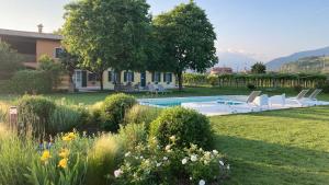 a garden with chairs and a swimming pool at B&B CAMPAGNON VALPOLICELLA in SantʼAmbrogio di Valpolicella