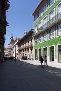 two people walking down a city street with buildings at OPO Downtown Blue in Porto