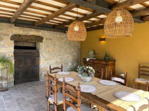 a dining room with a table and chairs and lights at Casatona in San Mateo de Bages