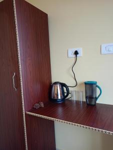 a tea kettle on a wooden shelf in a room at Chill with pahadi in Lansdowne