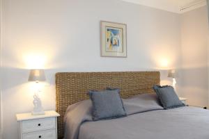 a bedroom with a bed with blue pillows on it at Hotellerie de l'Esplanade in Rians