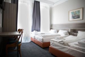 a hotel room with two beds and a desk at City Hotel - HEEFA OHG in Hamburg