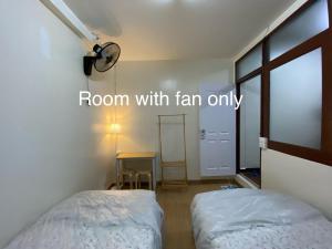 a room with two beds and a table with a window at PAMA'Pranakorn in Bangkok
