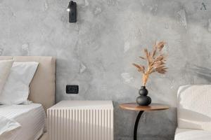 a bedroom with a vase on a table next to a bed at Studio in Dimri Residence in Bucharest +6 photos